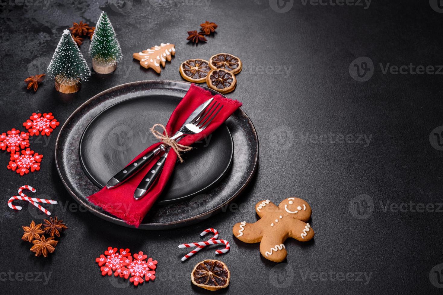 Christmas table setting with empty black ceramic plate, fir tree and black accessories photo