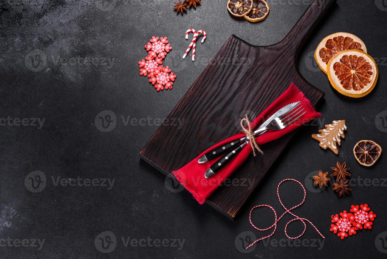 Christmas table setting with empty black ceramic plate, fir tree and black accessories photo