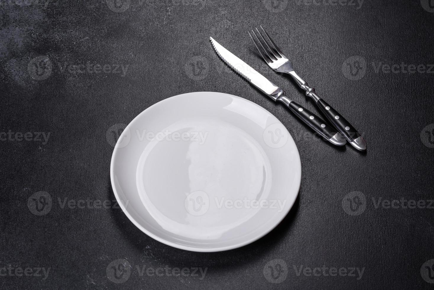 White plate on a black background. Flat lay, top view, copy space photo