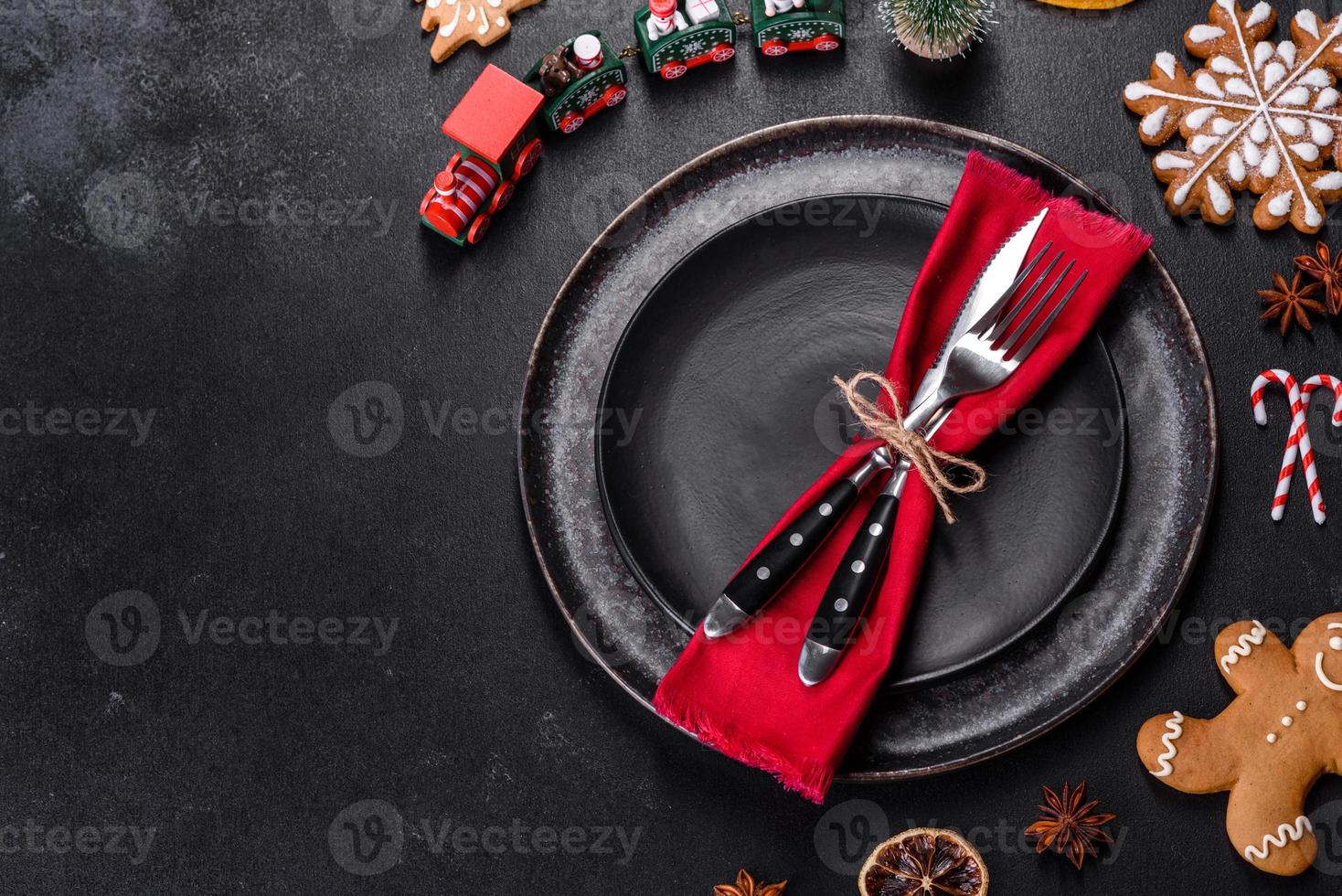 Christmas table setting with empty black ceramic plate, fir tree and black accessories photo