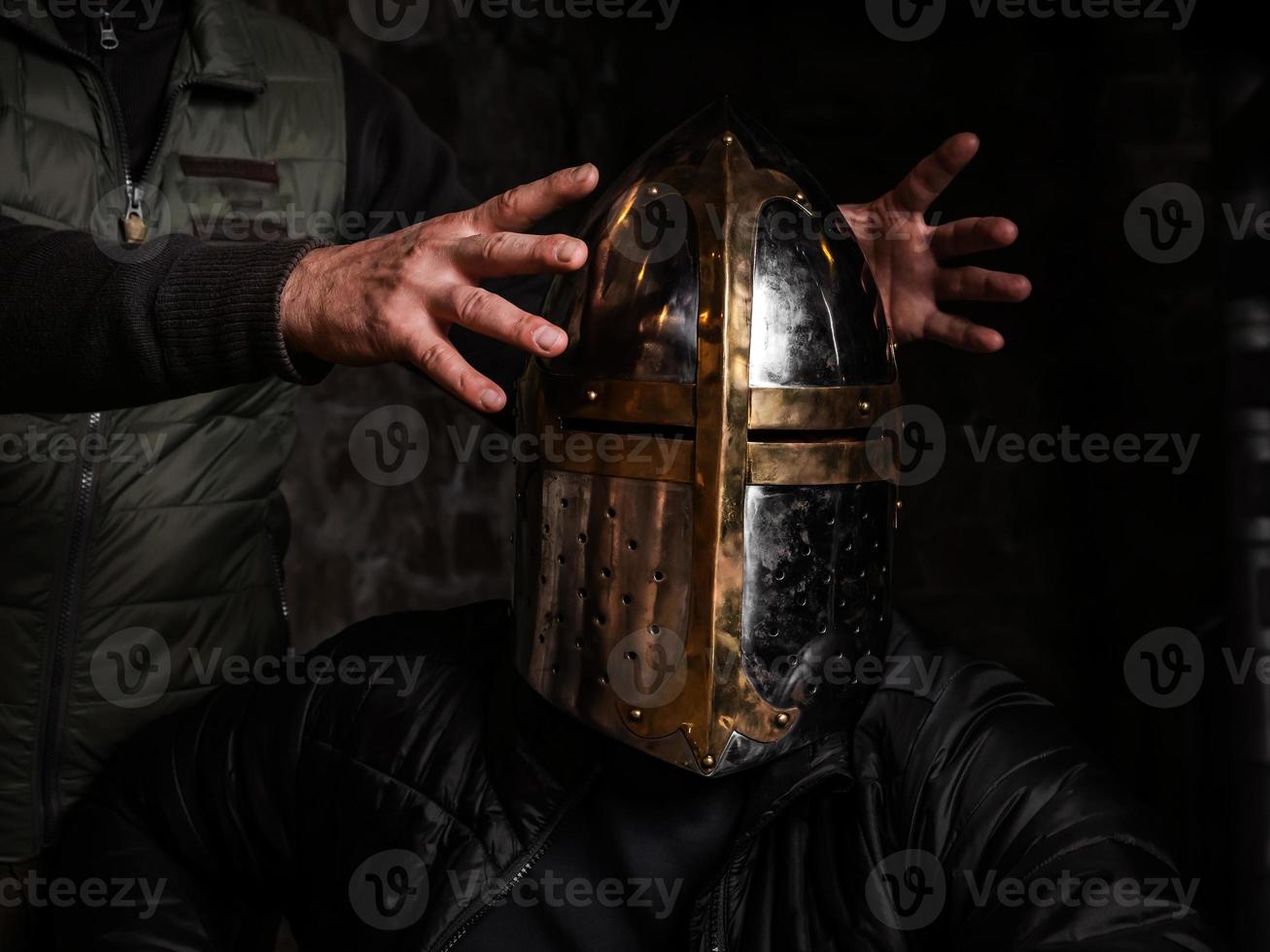 A man in a medieval iron knight's helmet. photo