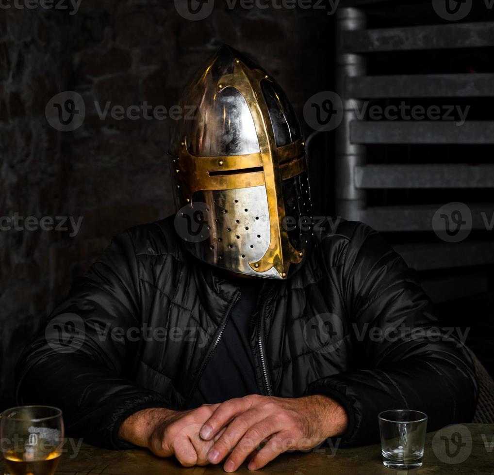 A man in a medieval iron knight's helmet. photo