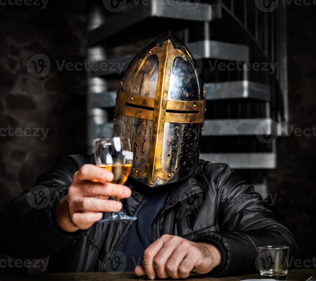 A man in a medieval iron knight's helmet. photo