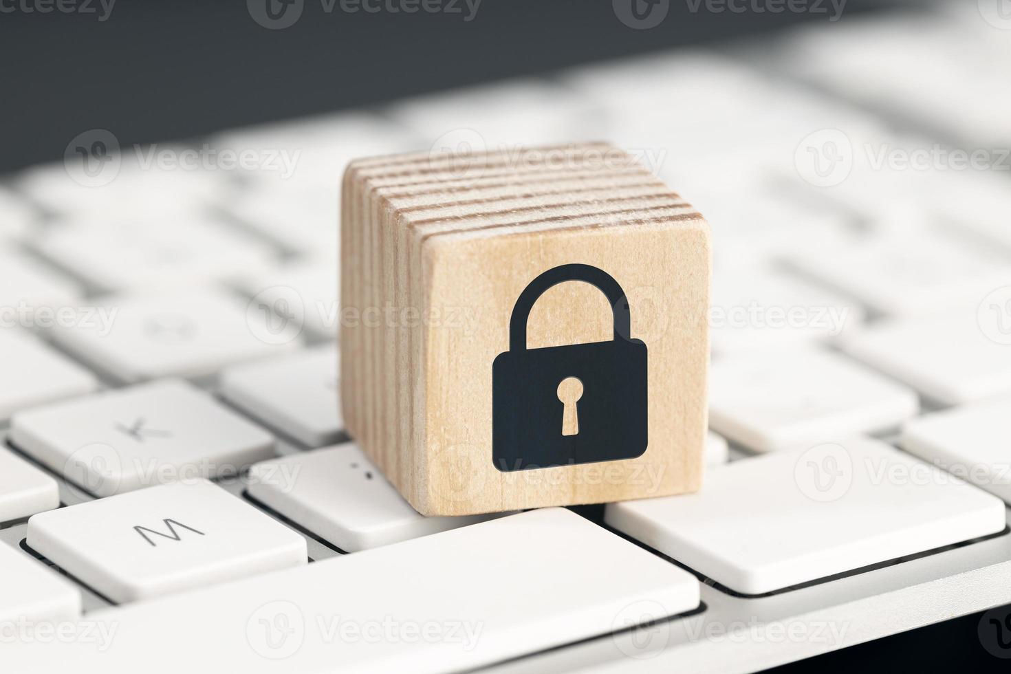 Computer Security protection concept. Cyber attack protection. Closed padlock icon on wooden block on computer keyboard photo