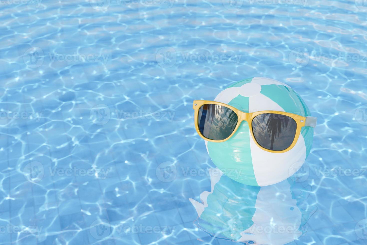 sunglasses on inflatable ball in swimming pool photo