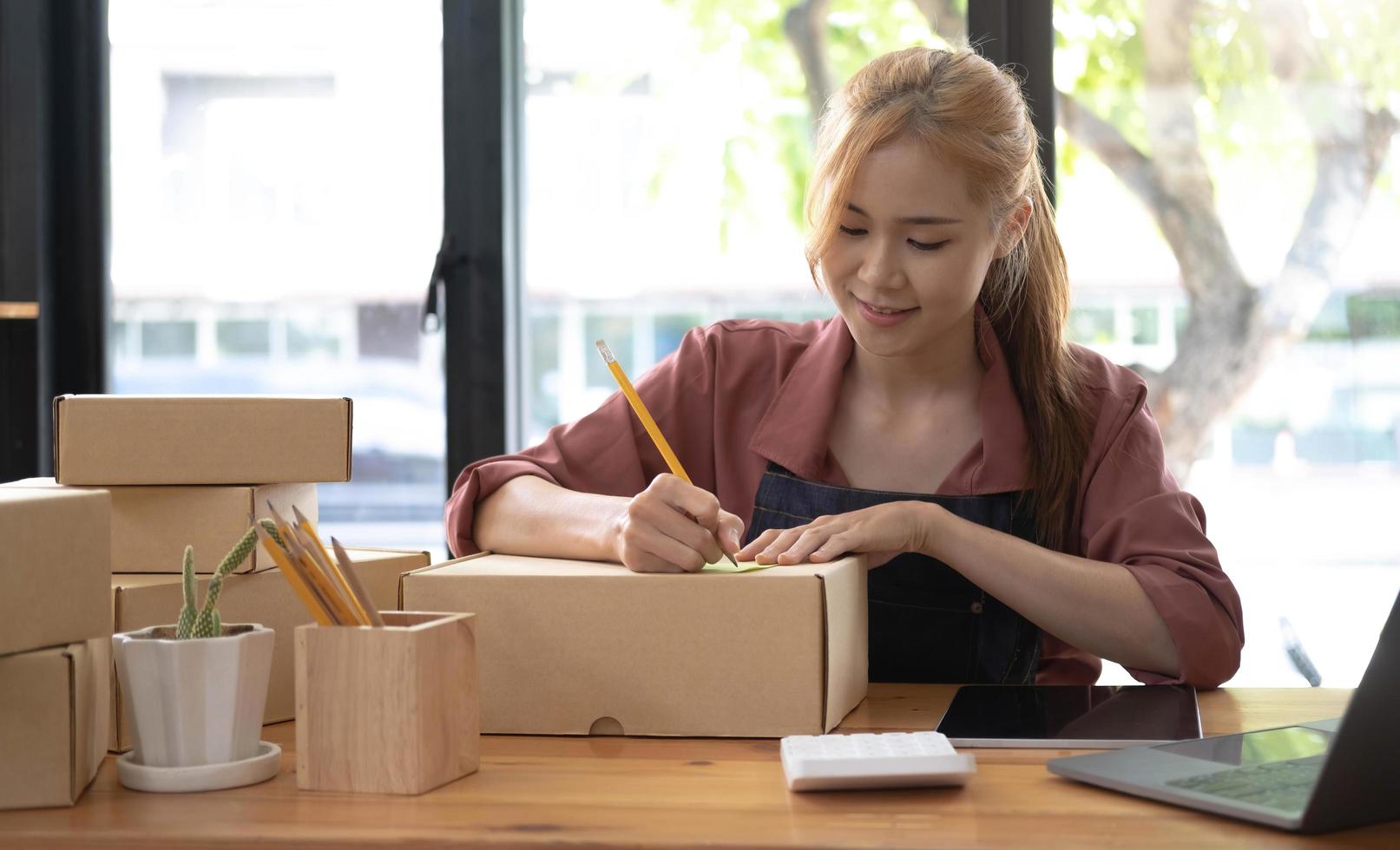 Starting Small business entrepreneur SME freelance,Portrait young woman working at home office, BOX,smartphone,laptop, online, marketing, packaging, delivery, SME, e-commerce concept photo