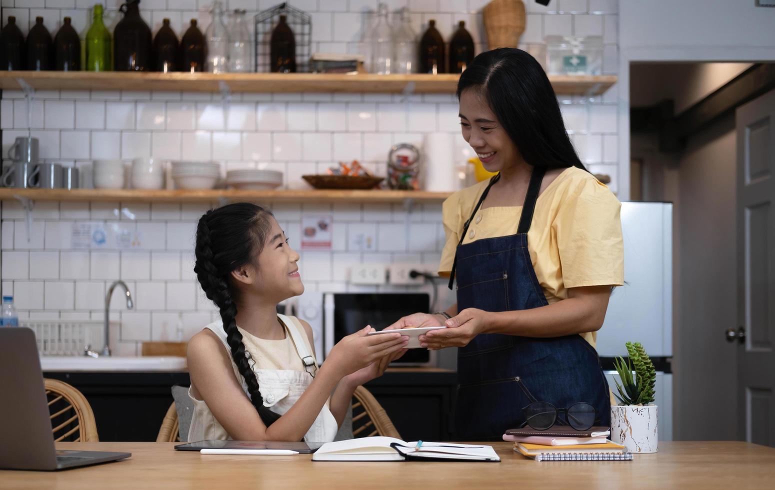 Happy mother and  little daughter eating  pizza for dinner together. mother and cute child girl kid enjoy eating and sharing a meal together at home photo