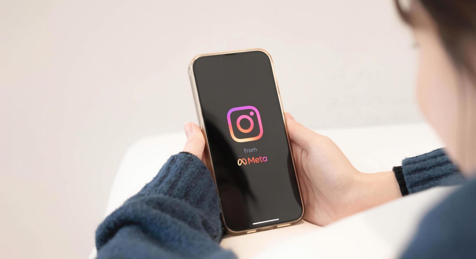 A woman holds Apple iPhone X with Instagram application on the screen at cafe. Instagram is a photo-sharing app for smartphones. photo