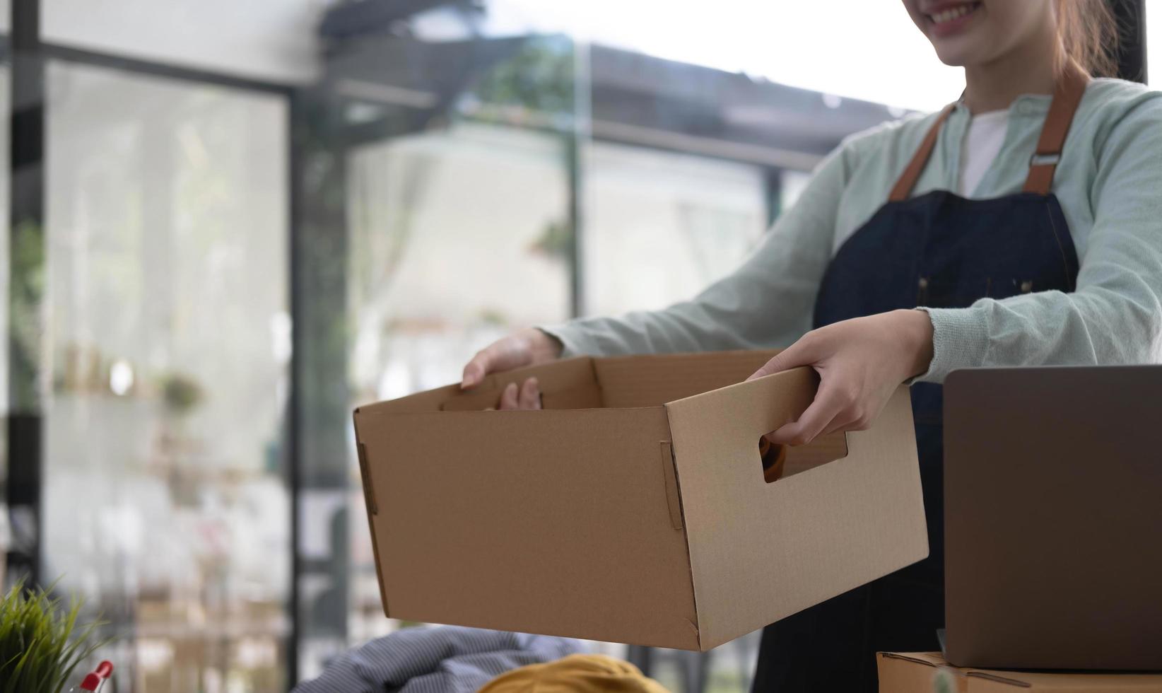 Starting small businesses SME owners female entrepreneurs Write the address on receipt box and check online orders to prepare to pack the boxes, sell to customers, sme business ideas online. photo