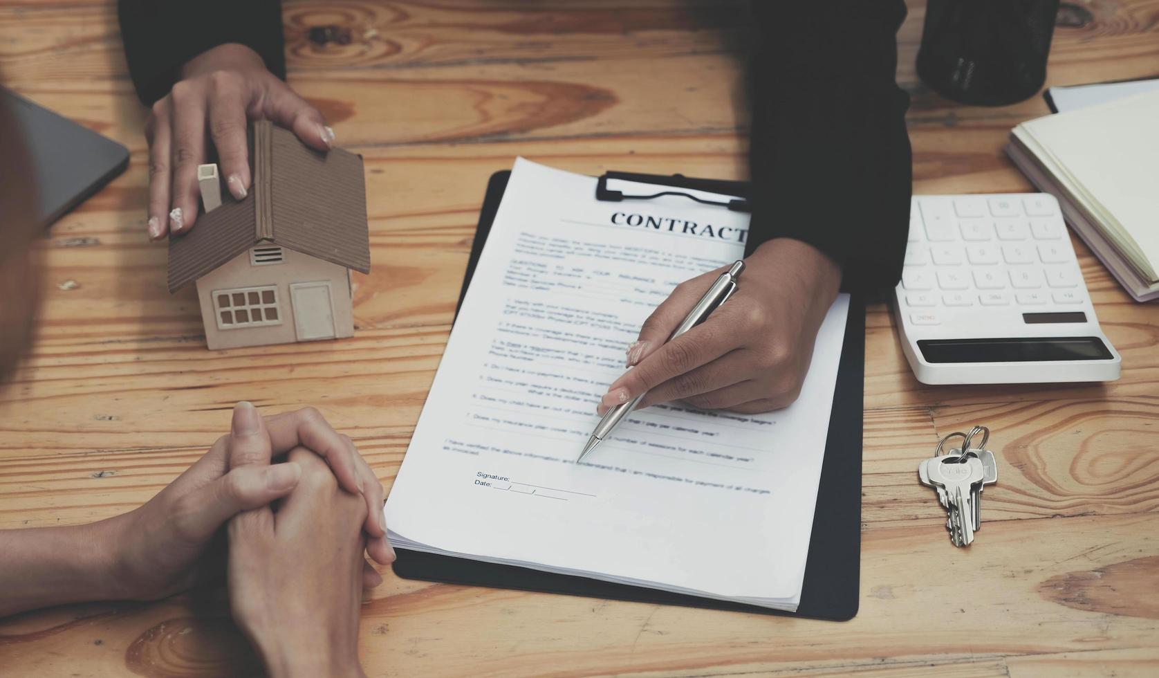 Real estate agent talked about the terms of the home purchase agreement and asked the customer to sign the documents to make the contract legally, Home sales and home insurance concept. photo