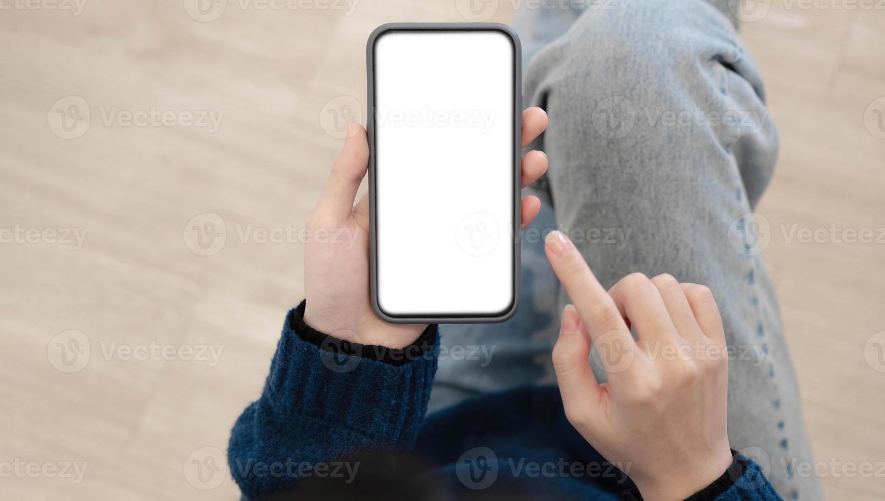 vista superior de manos de mujer sosteniendo un teléfono inteligente con pantalla de espacio de copia en blanco para su mensaje de texto o contenido de información. foto
