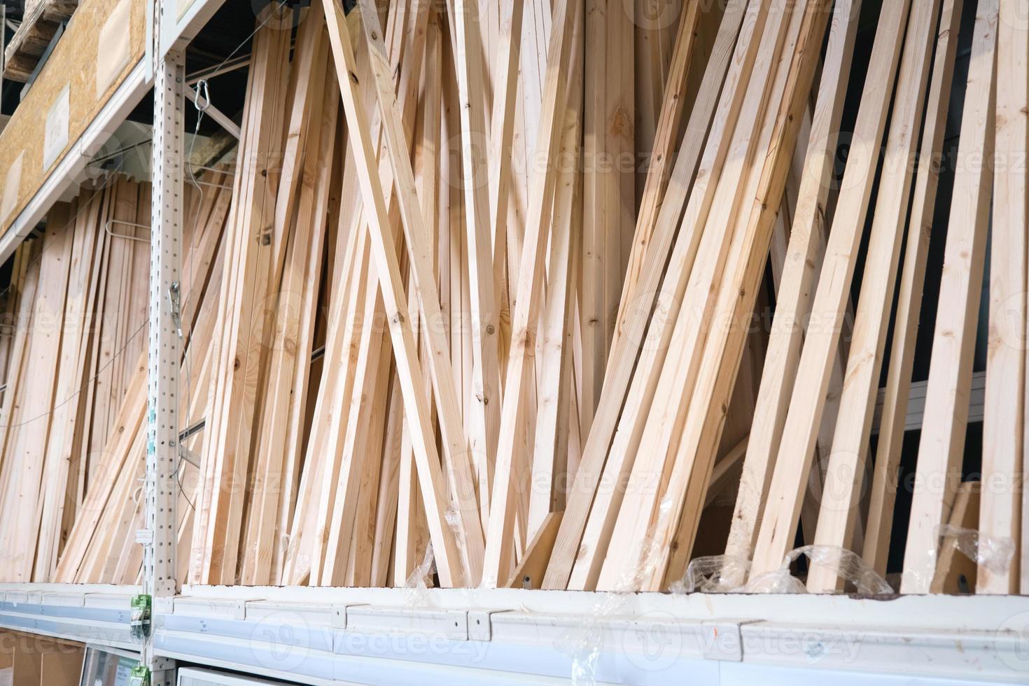 Wooden boards and bars in the warehouse of the building materials store for repair, decoration and construction of the house photo