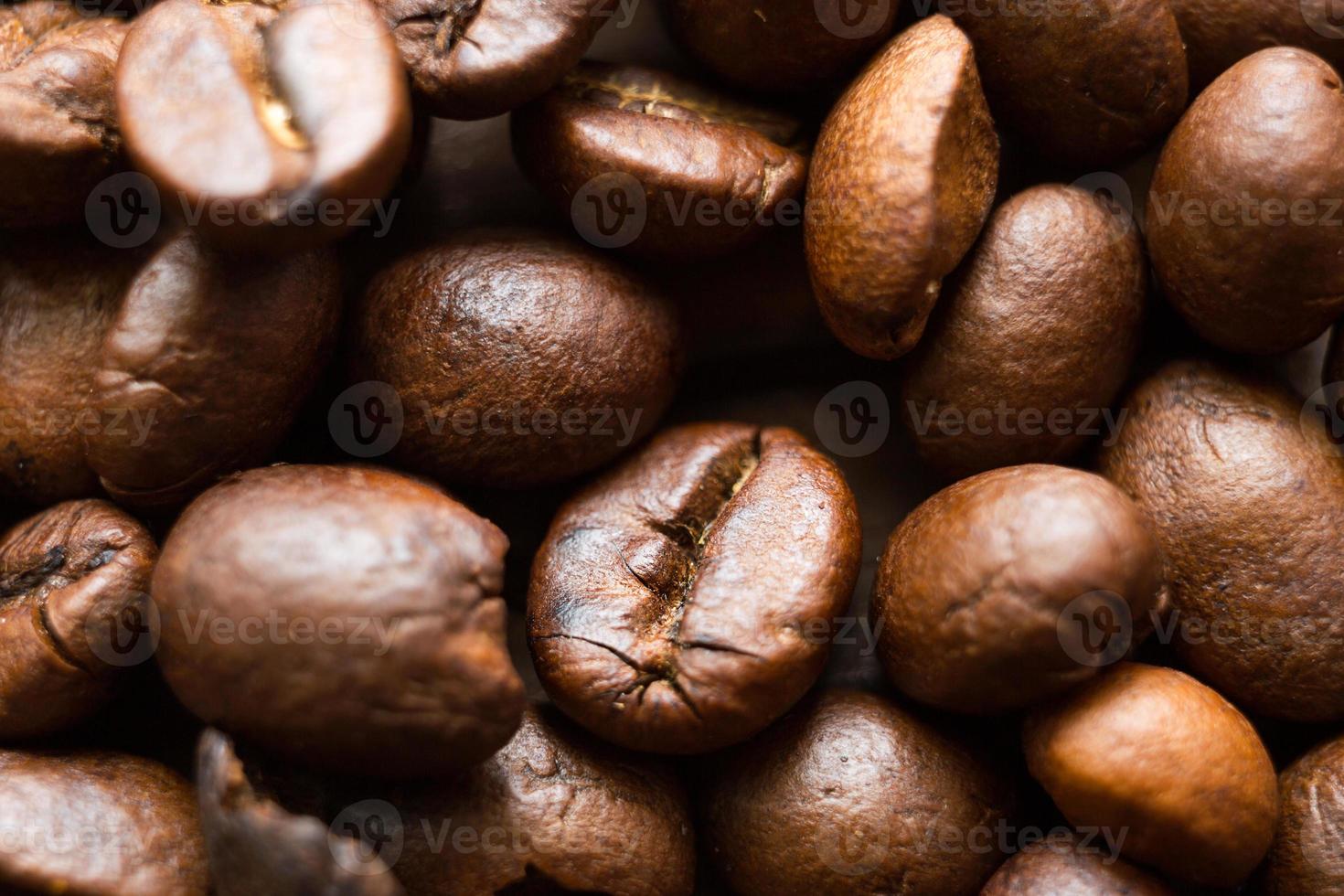 Roasted coffee beans close - up-fragrant background. Brown arabica coffee beans are scattered on the wooden table. Copy space photo