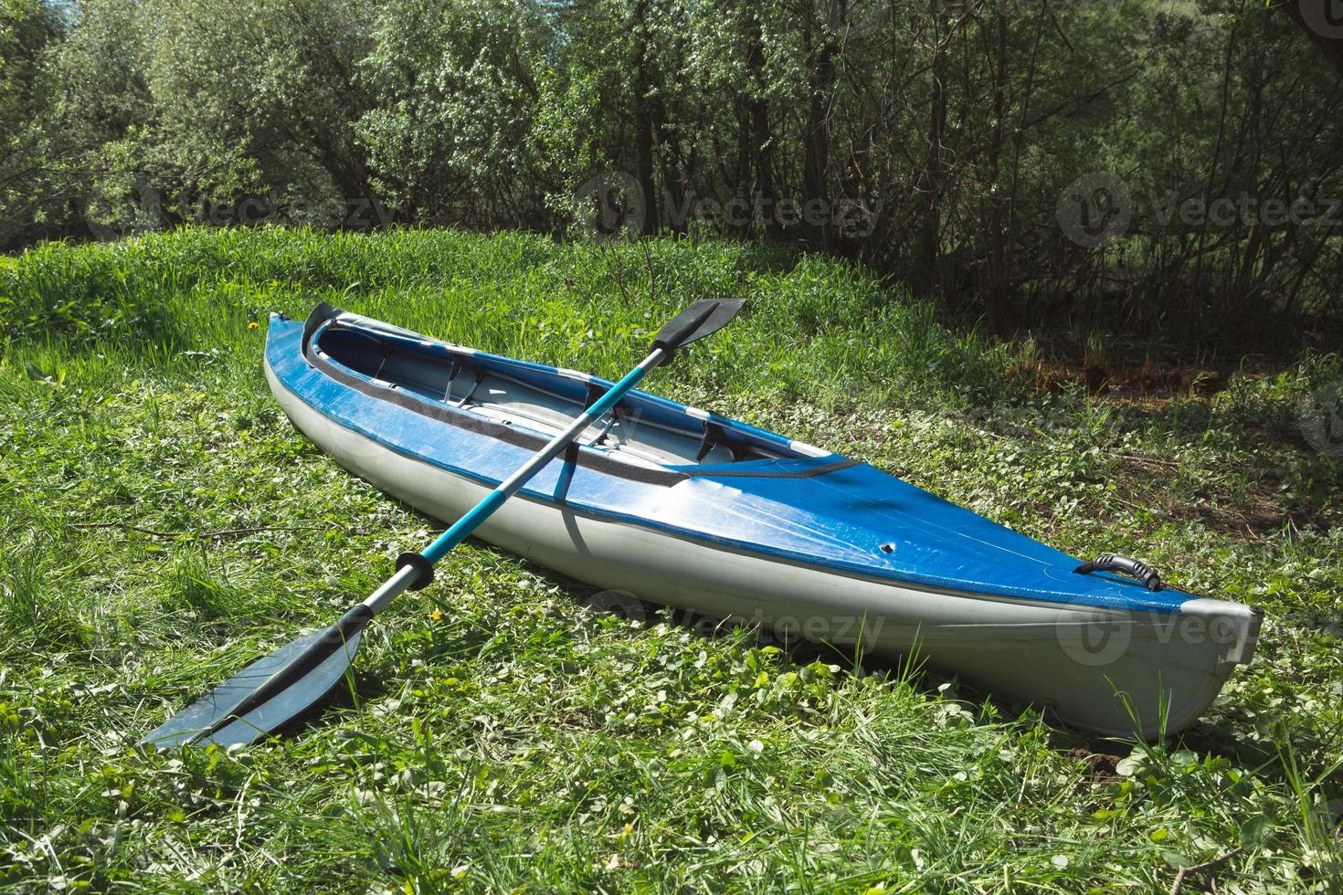 Tourist canoes with paddles stand on the river coast in summer on a water hike. Rafting on inflatable and frame double and triple kayak boats, family trip, extreme adventure in summer photo