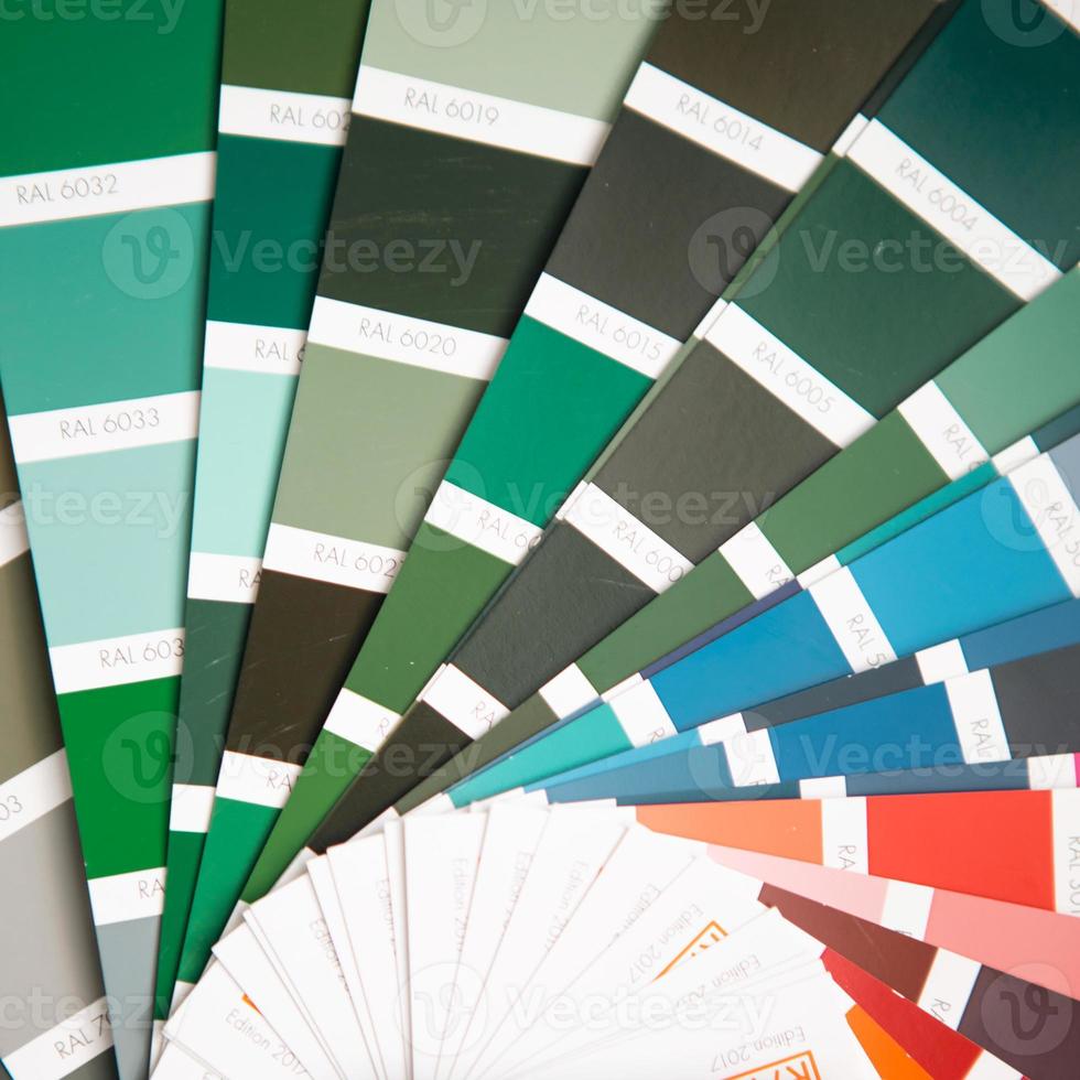 Selection of the paint color for decorative home repairs to the palette with layouts. A fan of shades in your hand inside the home. Repair and construction, paint and varnish coating photo