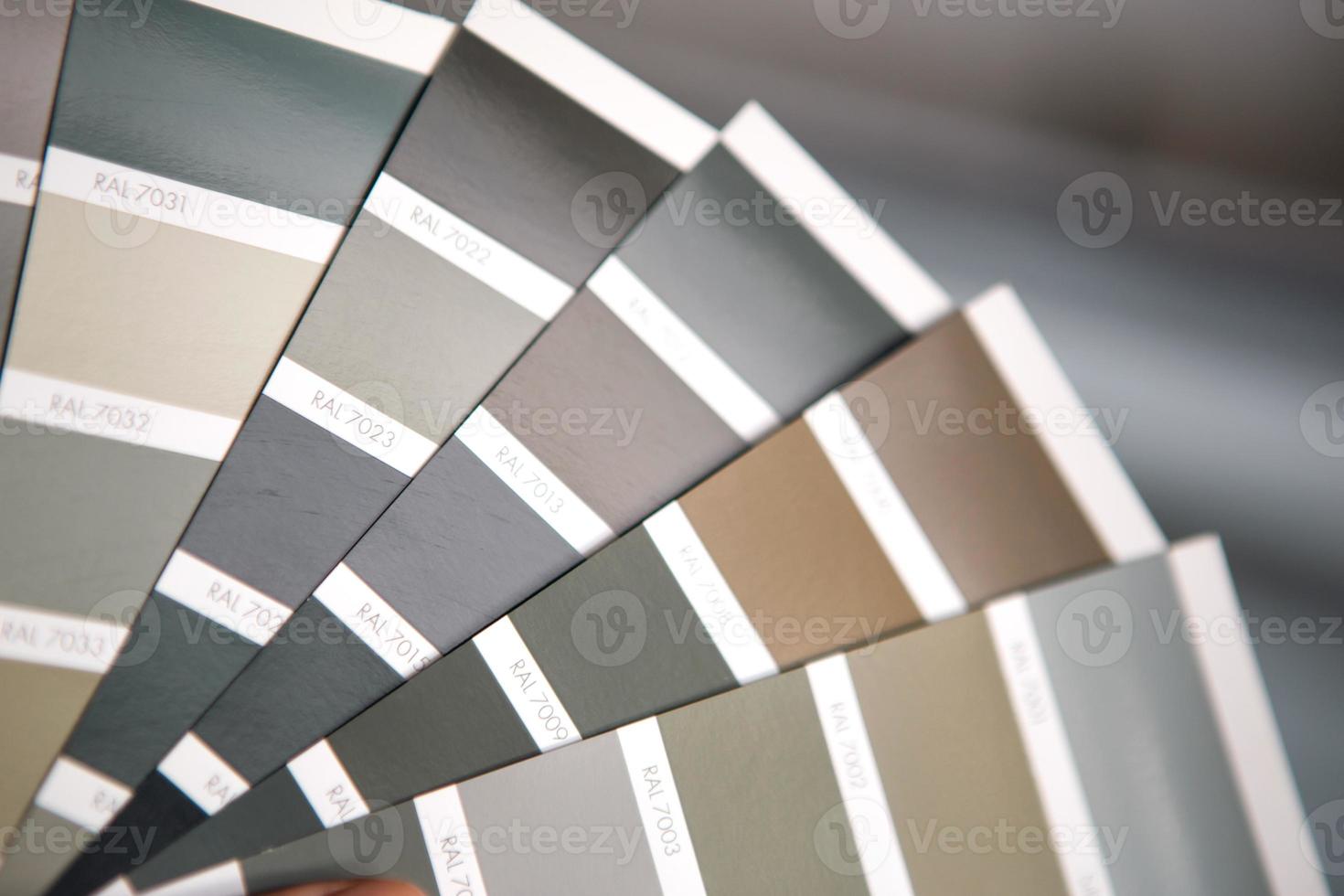 Selection of the paint color for decorative home repairs to the palette with layouts. A fan of shades in your hand inside the home. Repair and construction, paint and varnish coating photo