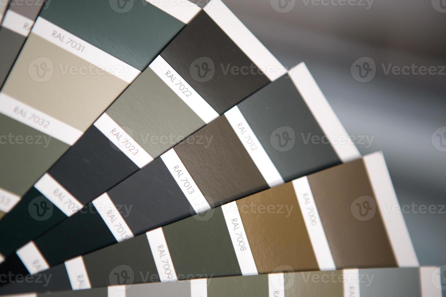 Selection of the paint color for decorative home repairs to the palette with layouts. A fan of shades in your hand inside the home. Repair and construction, paint and varnish coating photo