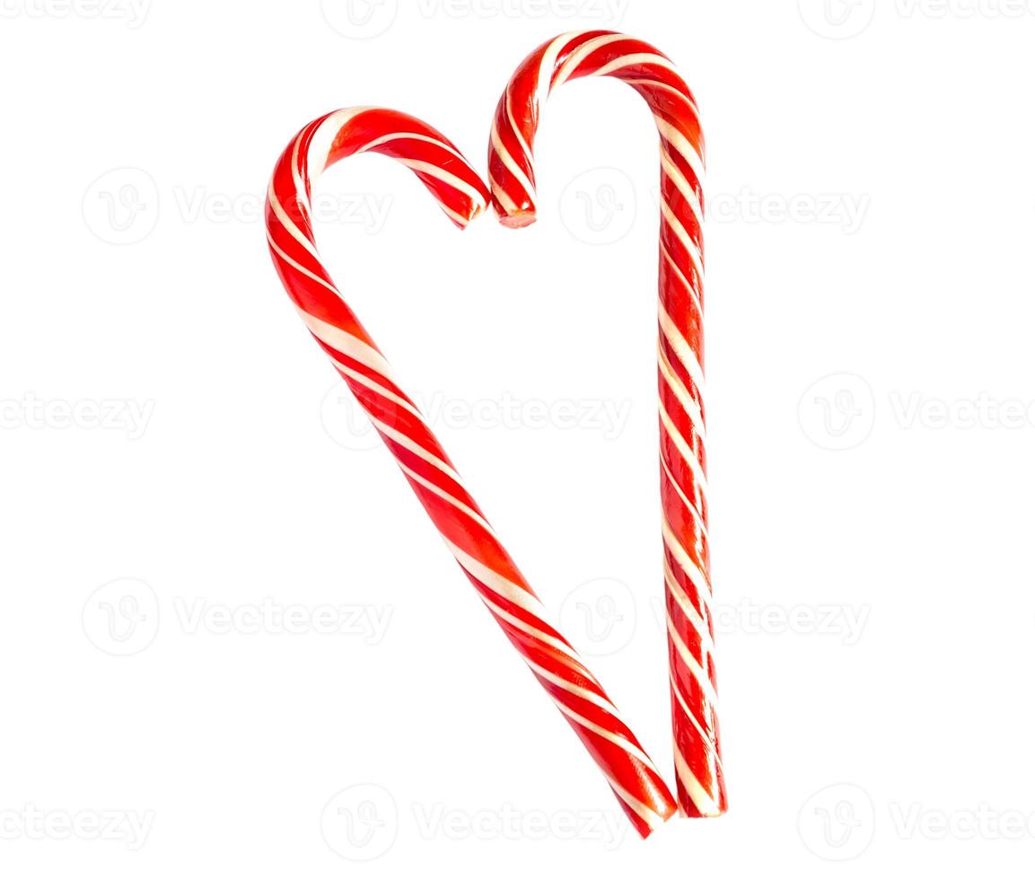Two red striped candy canes of Santa are stacked in the shape of a heart on white background. Isolate, frame. Christmas, new year, Valentine's day, winter holiday atmosphere for lovers and loved ones photo