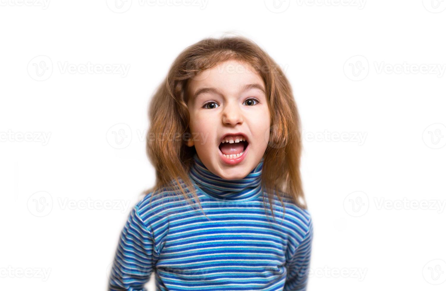 A small Caucasian girl in a blue striped turtleneck opened her mouth in indignation and twisted her face, wrinkling her nose. Denial, unpleasant, outrage, phew, disgusting. White background, isolate photo