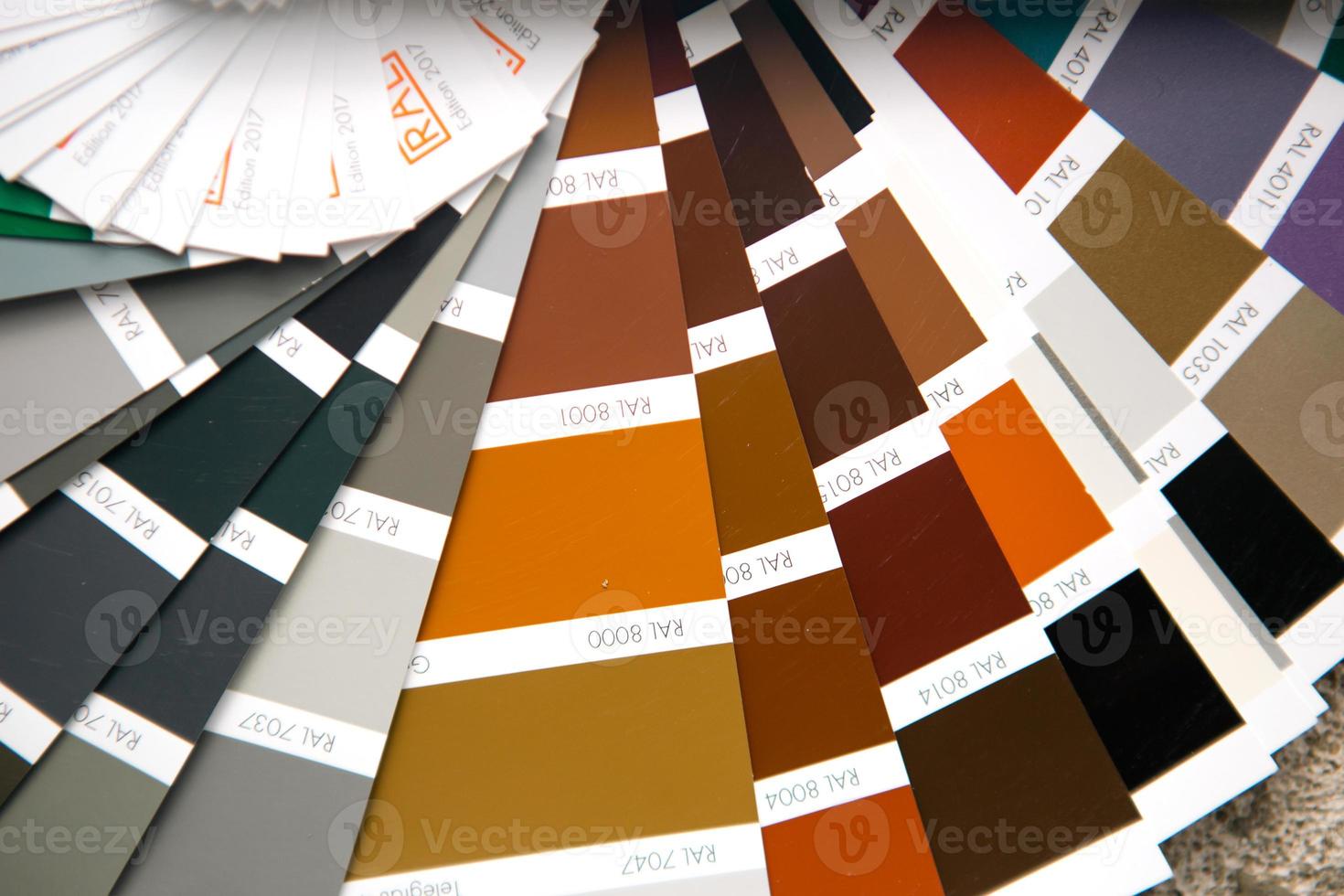 Selection of the paint color for decorative home repairs to the palette with layouts. A fan of shades in your hand inside the home. Repair and construction, paint and varnish coating photo