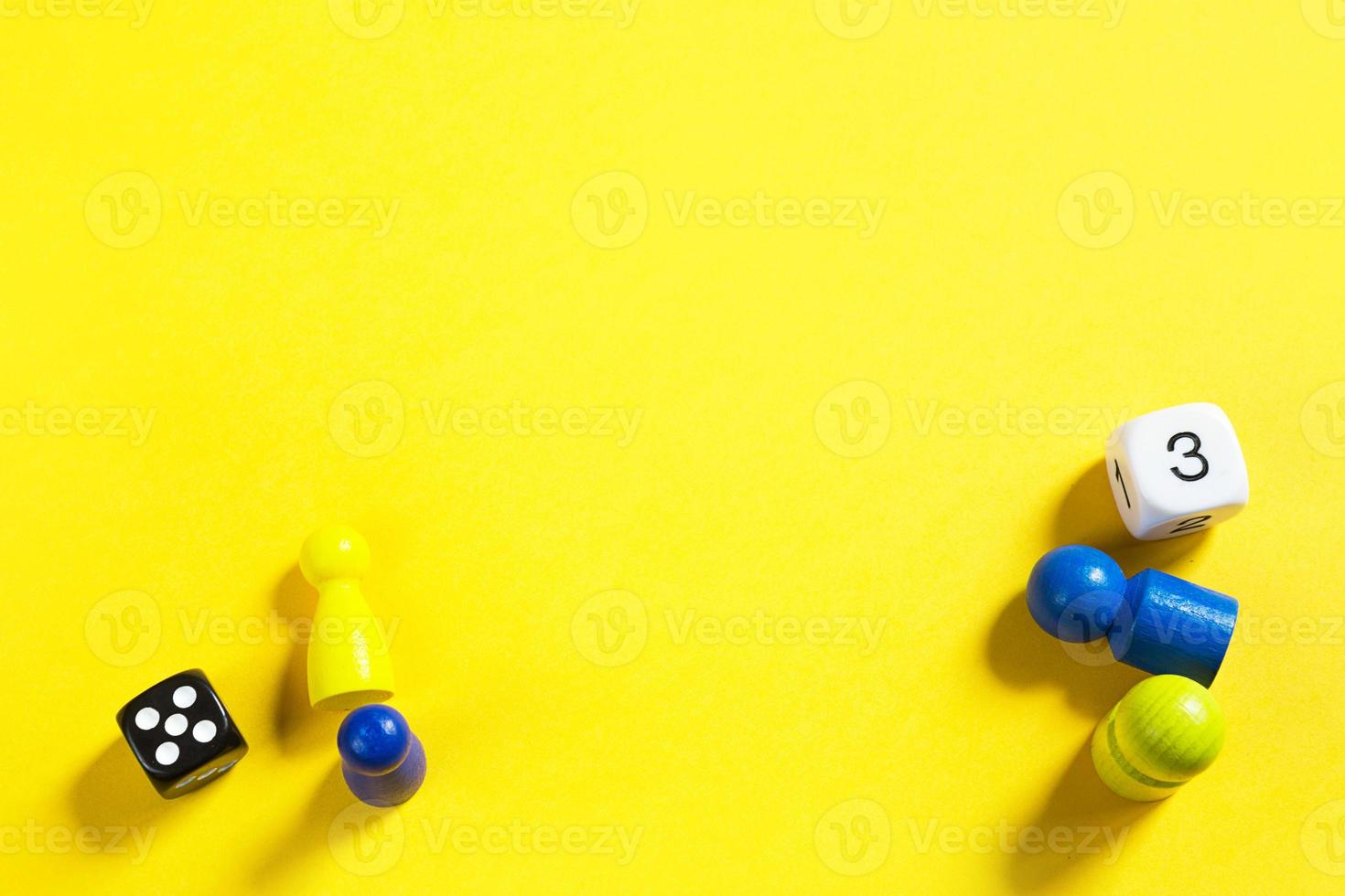 Layout of board games on a yellow background dice, chips, hourglass timer. Entertainment at home for children and adults. Copy space photo