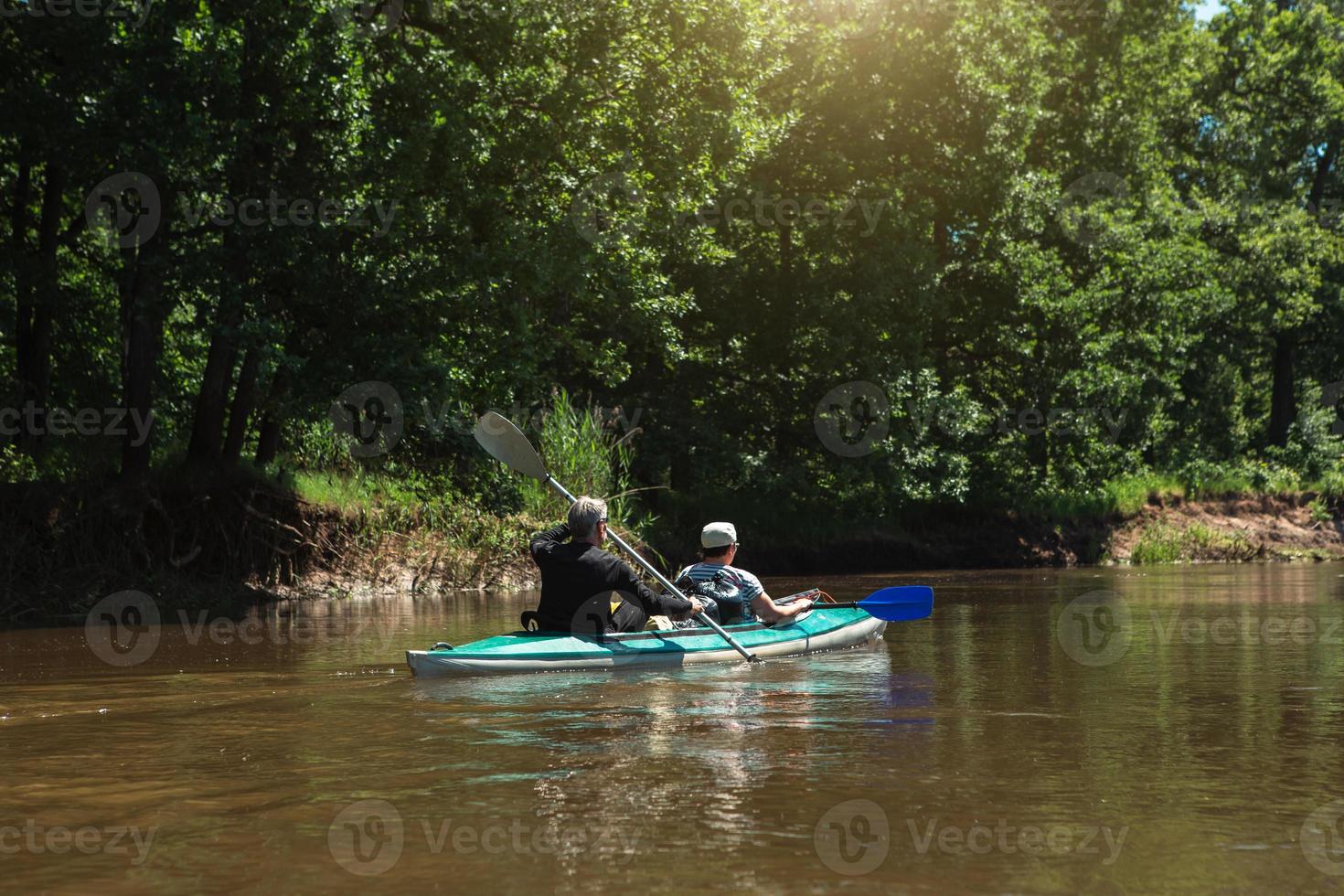 viaje familiar en kayak. una pareja de ancianos casados remando un bote en el río, una caminata acuática, una aventura de verano. deportes relacionados con la edad, salud y juventud mental, turismo, vejez activa foto