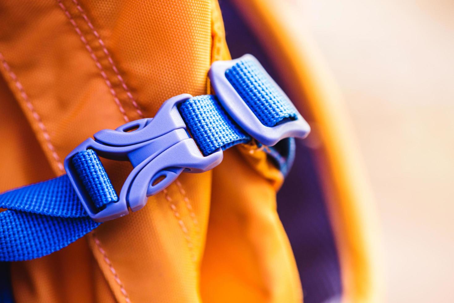 Close-up detail of locked blue convenient plastic clasp of backpack yellow. photo