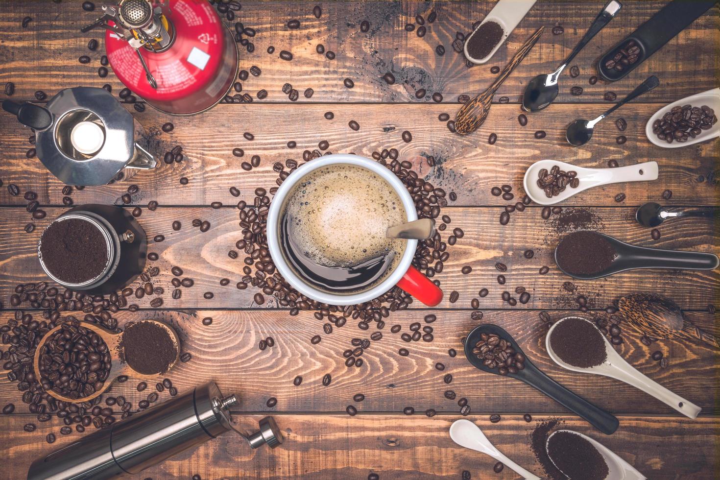 taza de café y molinillo de café con otros accesorios. espresso y frijoles. vista superior con espacio de copia para su texto. granos de café foto