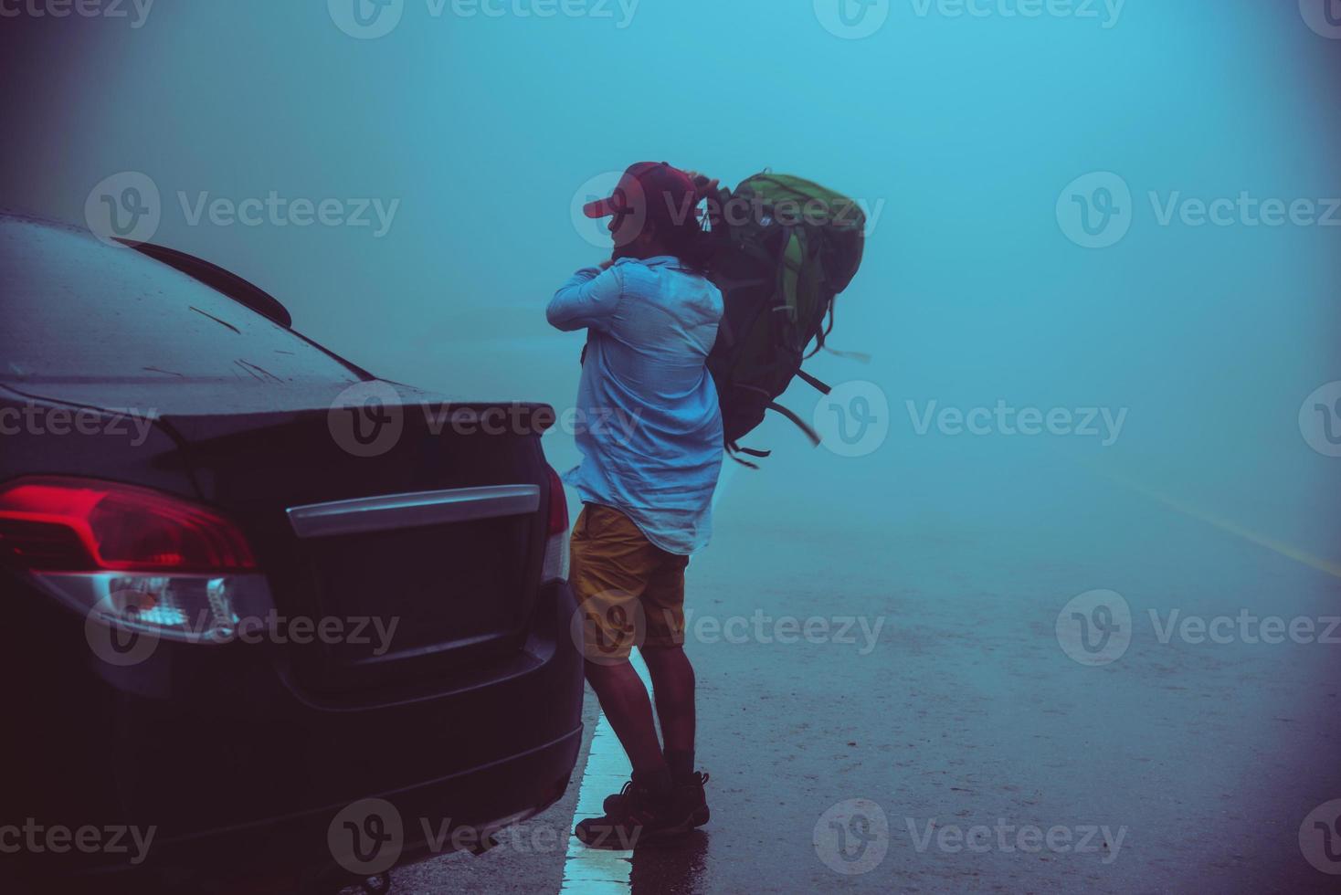 hombre asiático conduciendo un coche viajando relajarse naturaleza. naturaleza viajera en medio de la niebla lluviosa. en la temporada de lluvias en chiangmai en tailandia. foto