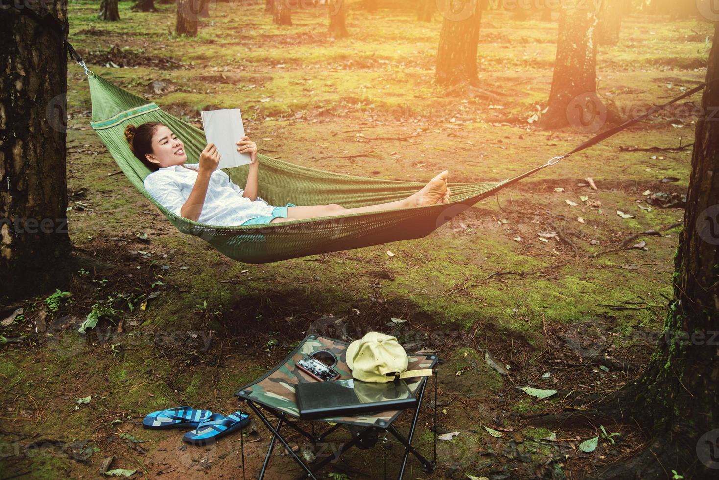 Asian women natural travel relax in the holiday. sleeping reading a book in the hammock. camping on the national park  Doi inthanon at Chiangmai. in Thailand photo