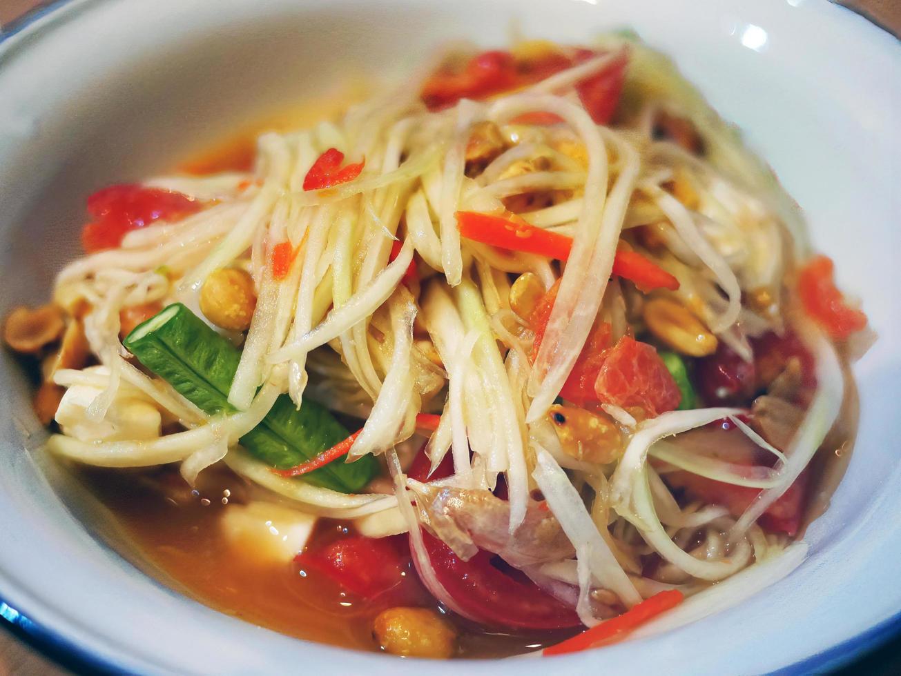 close up of papaya spicy salad tomato garlic chilli thai food local name somtum photo