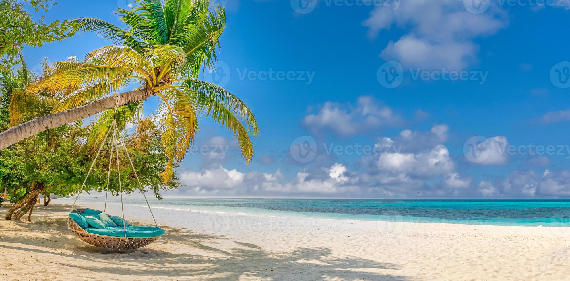 Tropical beach background as summer relax landscape with beach swing or hammock and white sand and calm sea for beach template. Amazing beach scene vacation and summer holiday concept. Luxury travel photo