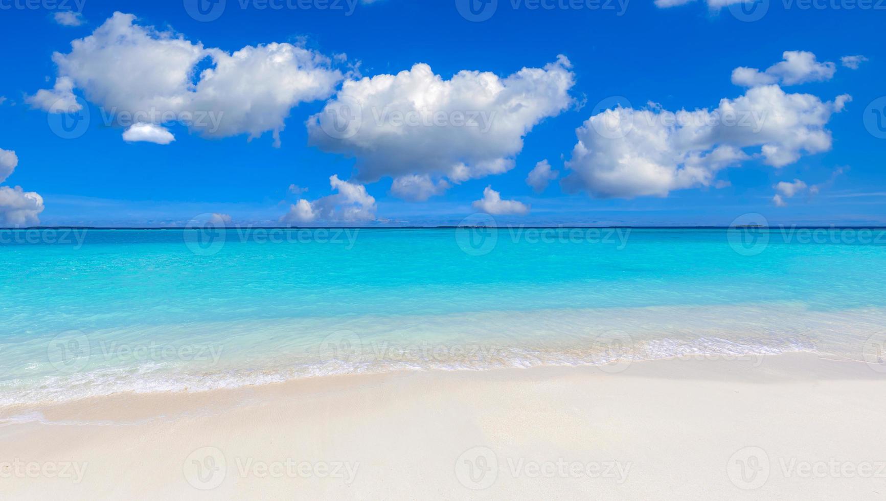 primer plano de arena en la playa y cielo azul de verano. paisaje panorámico de la playa. playa tropical vacía y paisaje marino. nubes soleadas de cielo azul brillante, arena suave, calma, luz solar tranquila y relajante, estado de ánimo de verano foto