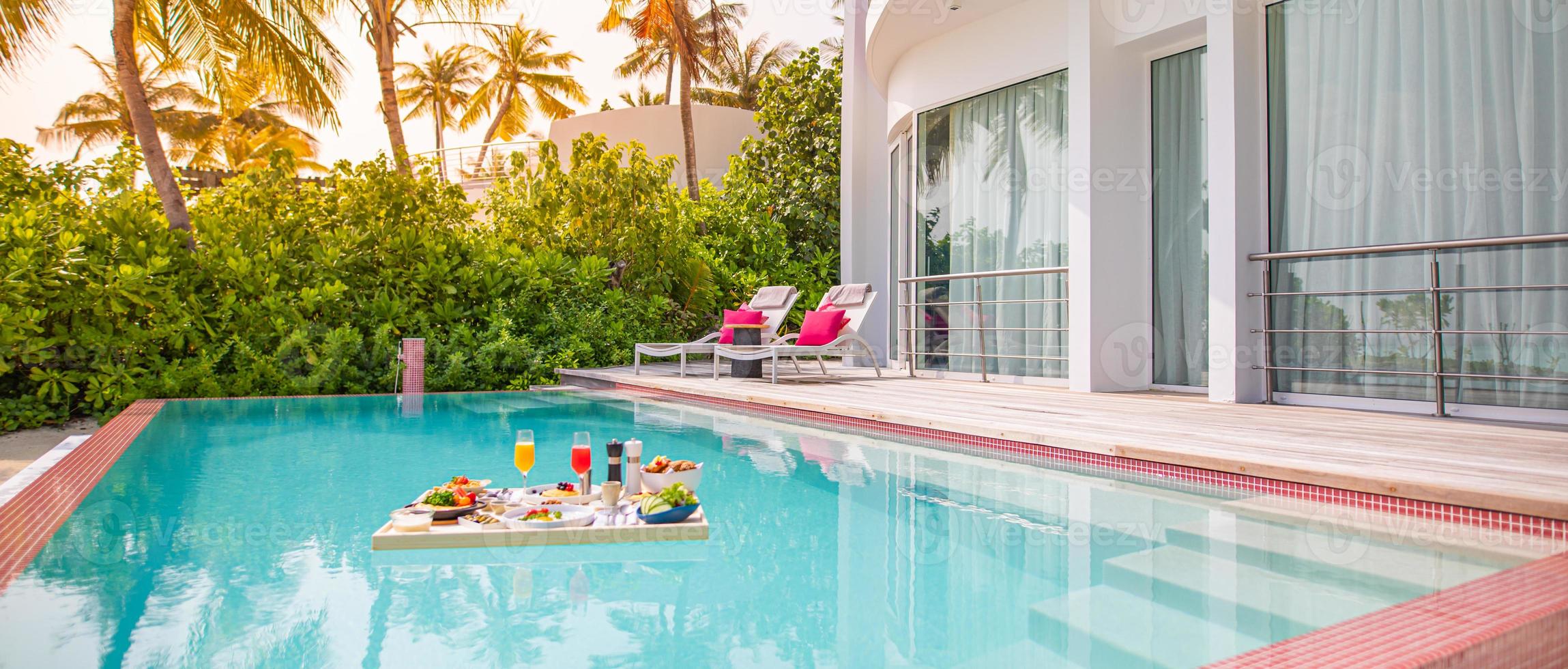 Breakfast in swimming pool, floating breakfast in tropical resort. Table relaxing in calm pool water, healthy breakfast and fruit plate by resort pool. Exotic summer diet. Tropical beach lifestyle photo