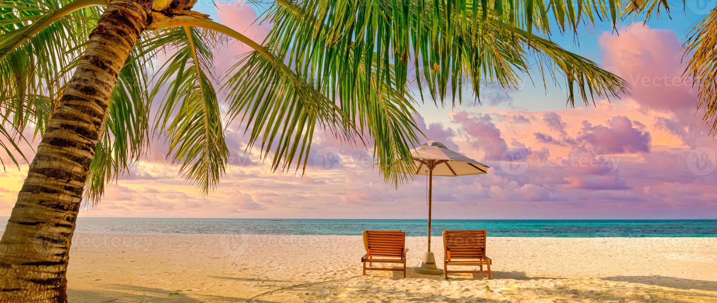 hermosa playa. sillas en la playa de arena cerca del mar. concepto de vacaciones y vacaciones de verano para el turismo. paisaje tropical inspirador. panorama tranquilo, playa relajante, diseño de paisaje tropical foto