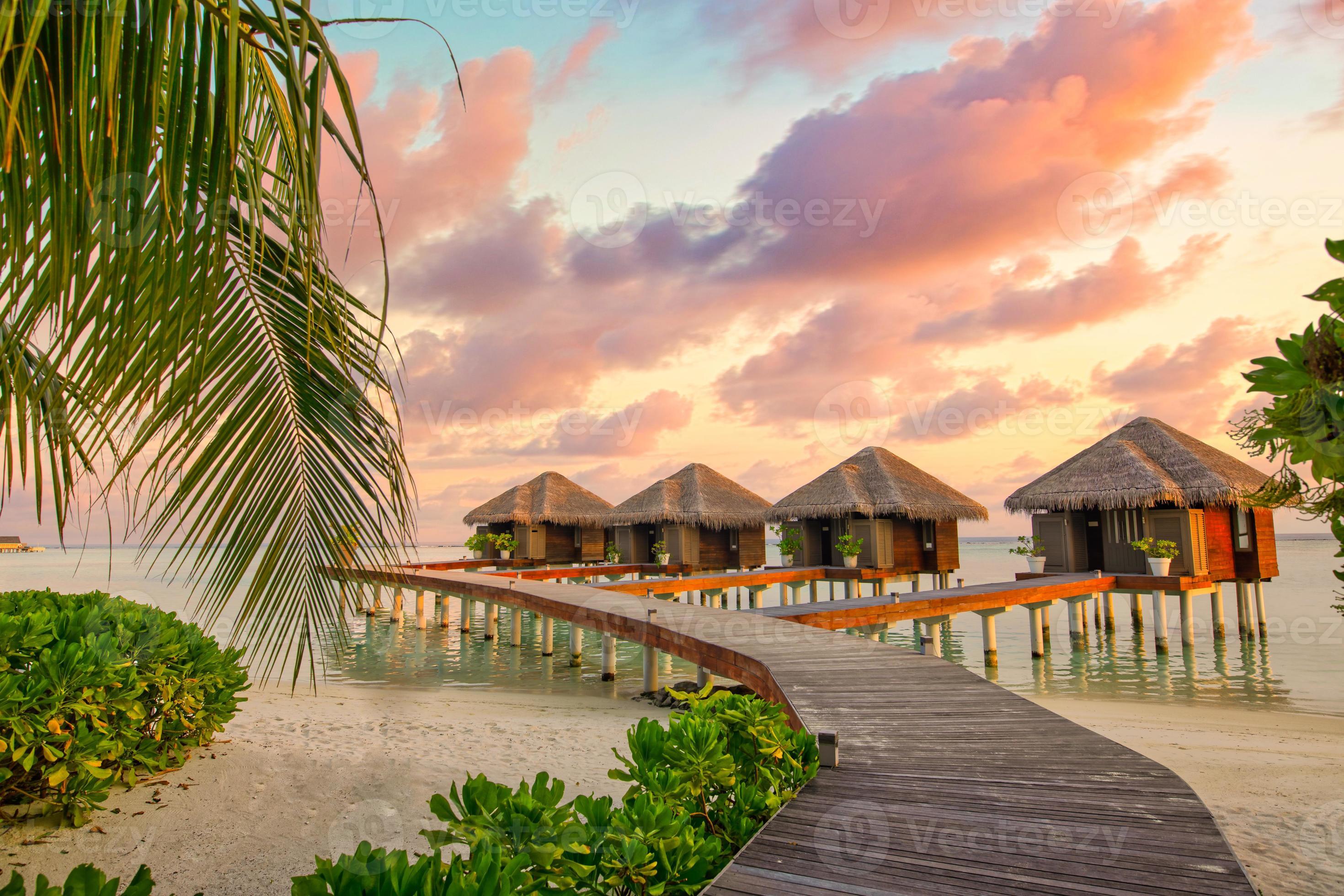 Sunset on Maldives island, luxury water villas resort and wooden pier