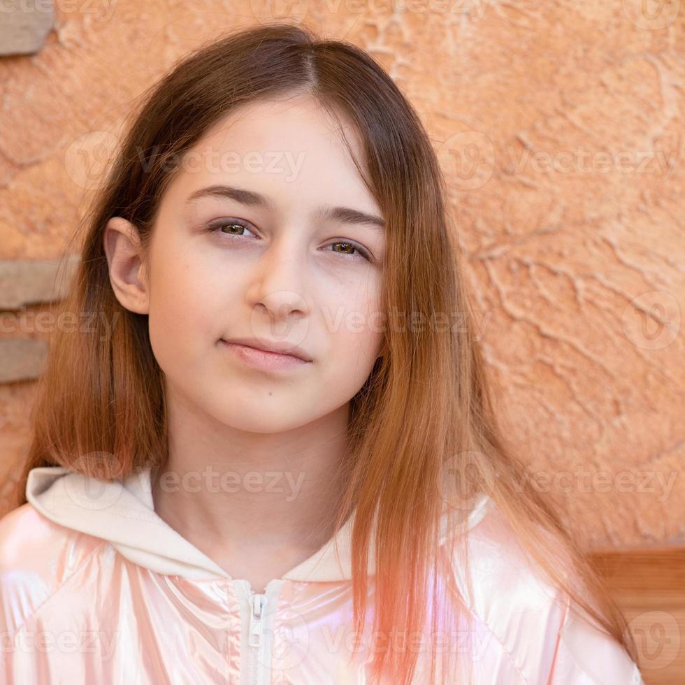 Girl 11 years old on a background of beige wall. Teen girl portrait. photo