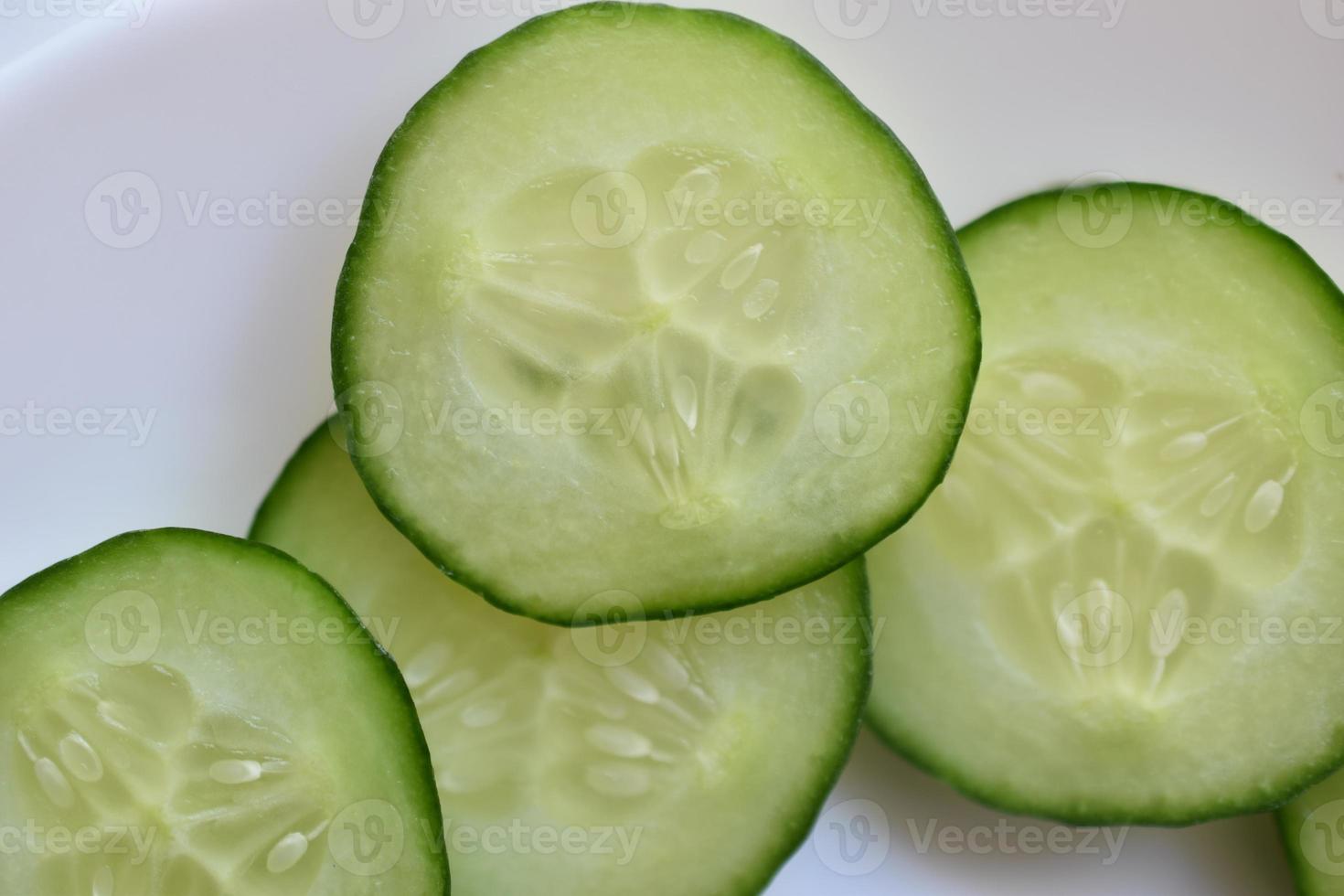 Sliced slices of green cucumber macro photo as background