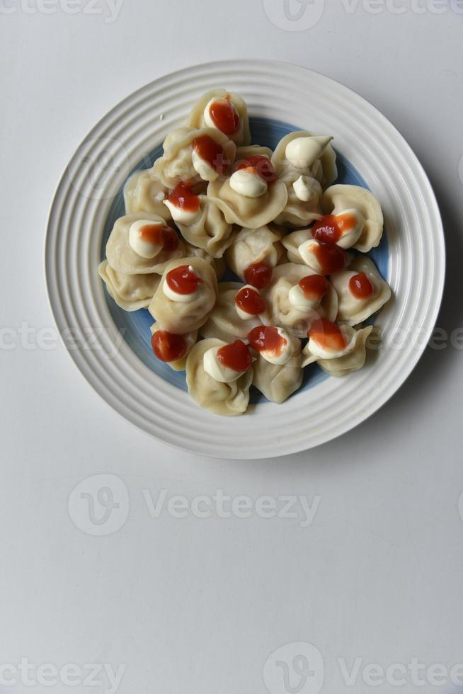 Cooked dumplings on a plate with ketchup and mayonnaise photo