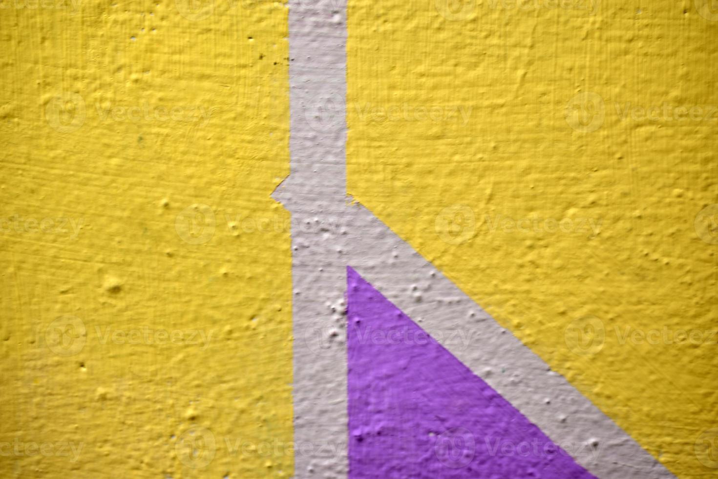 A yellow and blue wall painted with stripes and a triangle photo