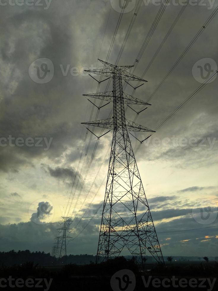 Several electric towers stand with the atmosphere of the sky full of dark clouds photo