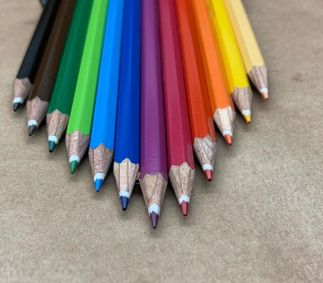 A set of colored wooden pens used for coloring and drawing, stacked horizontally next to each other photo