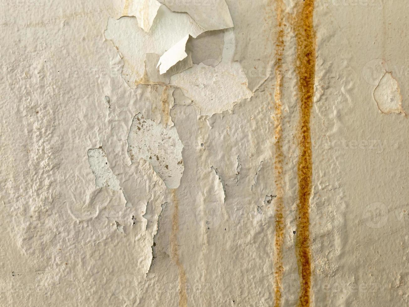 old wall texture There are traces of moisture causing delamination. There is a long line of rust stains running down vertically. photo