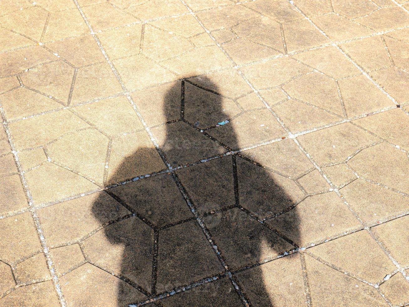 Tome una sombra de sí mismo en el camino Las sombras contra la luz del sol crean una forma oscura. mostrando diferentes superficies foto