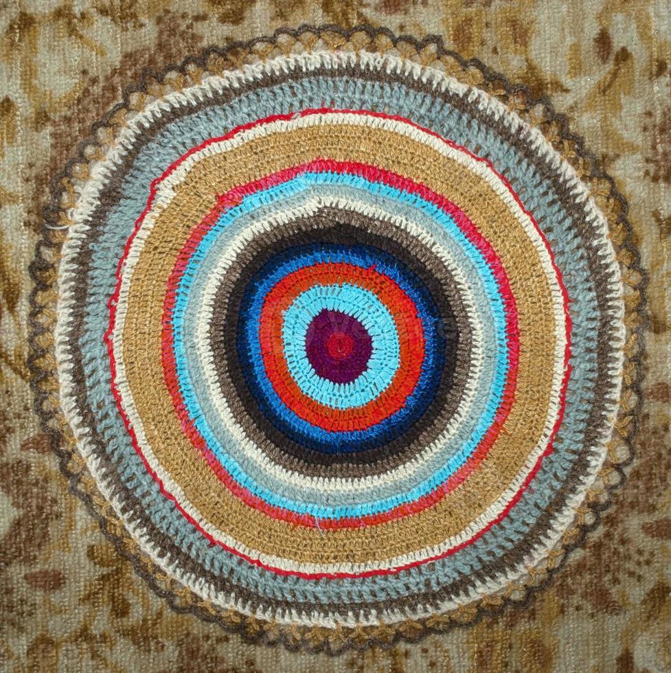 round knitted rug in different colors of threads photo