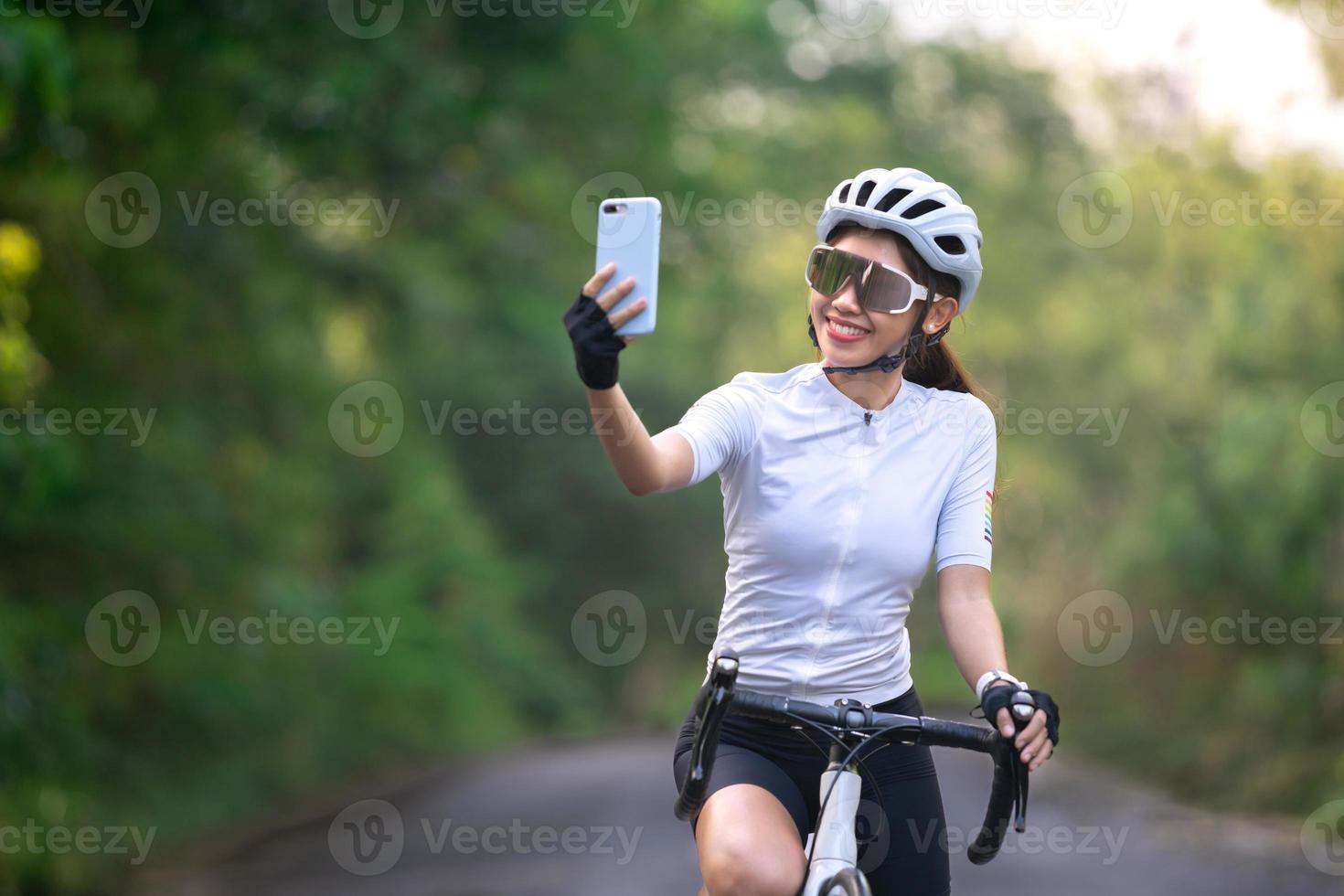 female cyclist cycling selfie woman social group with smart phone during ride bicycle for exercise and relax on mountain for healthy lifety on road or street photo