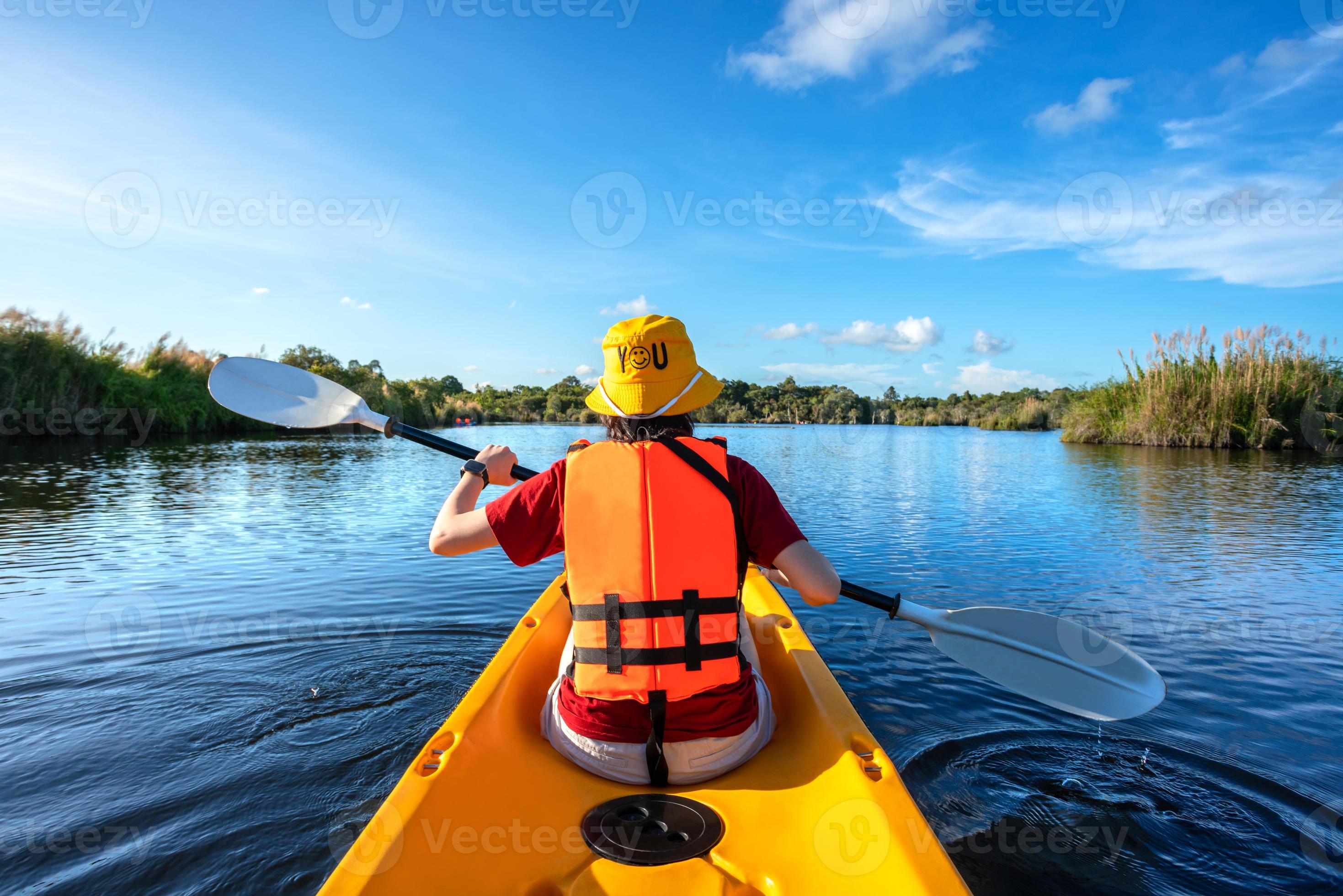 happy woman kayaking with kayak boat in nuture lake behind sea and