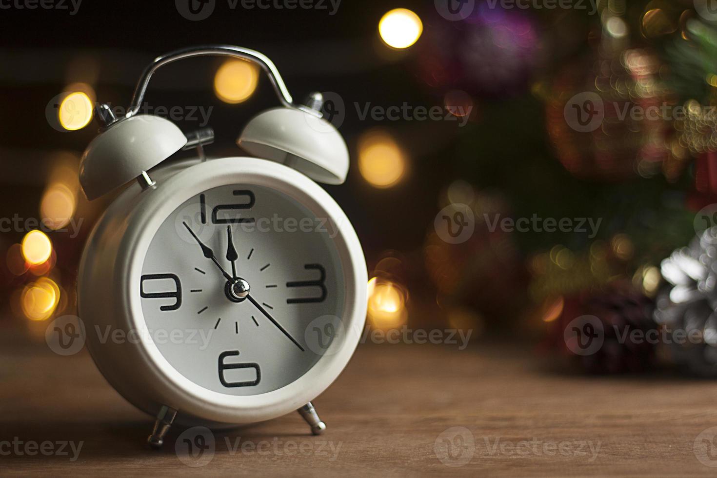 Christmas Retro alarm clock.decoratied with gift box and fir festive on blurred bokeh background.Celebration and Happy New Year Concept. photo