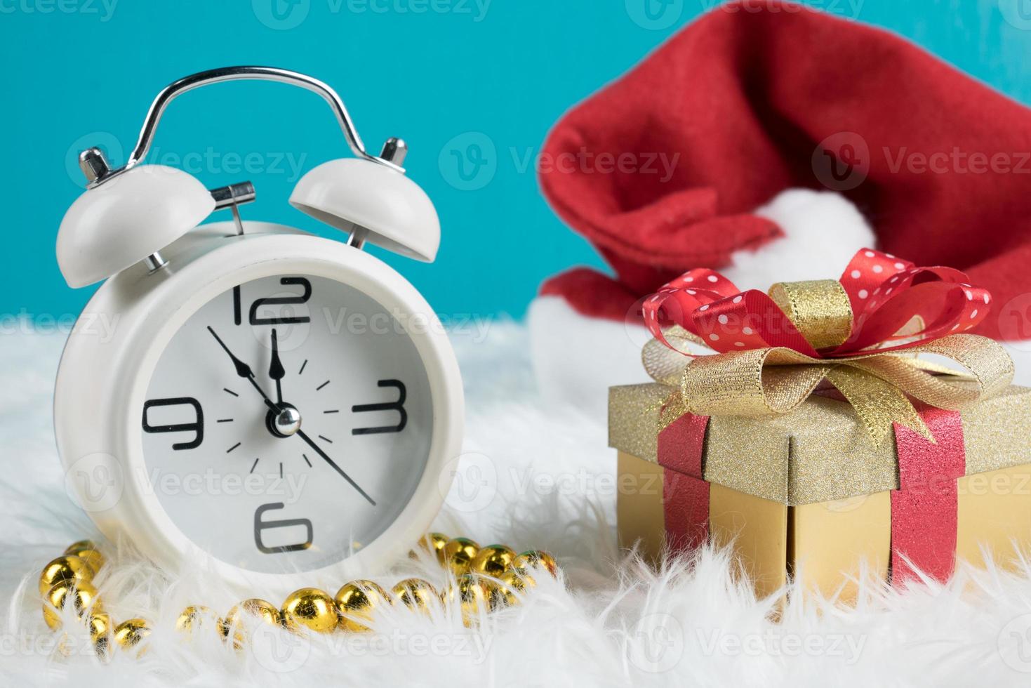 Christmas day theme decoration gift box with hat santa and white retro clock.copy space for text.Celebration Christmas and x'mas concept.on green background photo