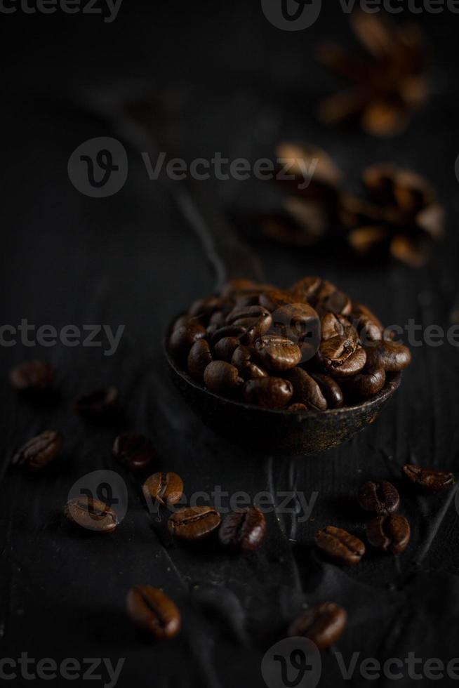 coffee beans in a vintage spoon on black background,angle view photo